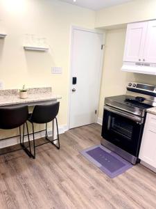 a kitchen with a stove and a table and chairs at The House Hotels - Erie Street 1 in Cuyahoga Falls