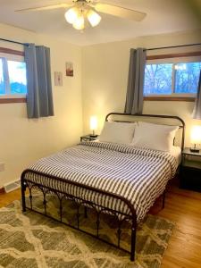 a bed in a room with two lamps and two windows at The House Hotels - Erie Street 1 in Cuyahoga Falls