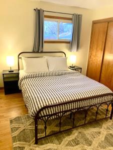 a bedroom with a bed with two lamps and a window at The House Hotels - Erie Street 1 in Cuyahoga Falls