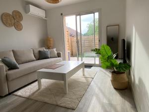 uma sala de estar com um sofá e uma mesa em Appartement à Villenave d'Ornon avec jardin fraîchement rénové em Le Brucat