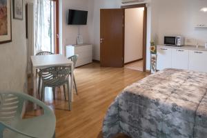 a bedroom with a bed and a table and a kitchen at LA VELA in Negrar