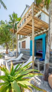Casa Tinti Hotel Boutique في Tintipan Island: منزل على الشاطئ مع بروجولا خشبي