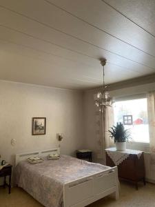 - une chambre avec un lit et un lustre dans l'établissement Omakotitalo Simojärvellä, à Ranua