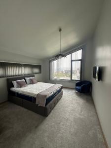 - une chambre avec un grand lit et une chaise bleue dans l'établissement Alexandra Family Estate, 
