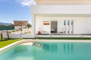 a swimming pool in front of a house at Villa Greca Holiday Rooms in Sant' Isidoro