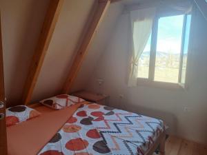 a small bedroom with a bed and a window at Gorska vila in Žabljak