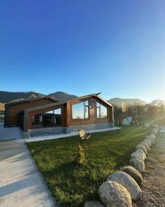 una casa in legno con una lunga linea di rocce di Alexandra Family Estate a Samoranovo