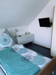 um quarto com uma cama com uma cómoda e uma televisão em Ferienwohnung Jasmin - a53959 em Maasholm-Bad