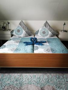 uma cama com cobertores e almofadas azuis e brancos em Ferienwohnung Jasmin - a53959 em Maasholm-Bad