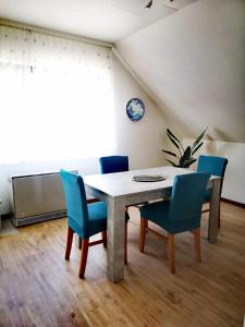 uma sala de jantar com uma mesa e cadeiras azuis em Ferienwohnung Jasmin - a53959 em Maasholm-Bad