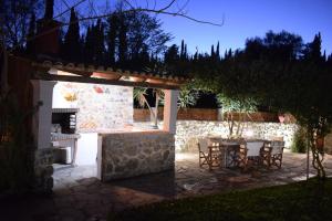 a patio with a table and chairs and a stone wall at Bruskos Holiday Deluxe in Kynopiástai