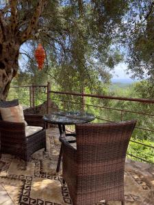 d'une terrasse avec une table, des chaises et un arbre. dans l'établissement Cozy Anthousa House with Sea View, à Anthoúsa