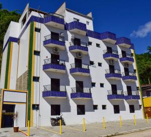 een gebouw met blauwe balkons aan de zijkant bij Flats e Apartamentos Temporada Mar Brasil in Ubatuba