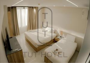 een slaapkamer met een wit bed en een spiegel bij TUT Hotel Downtown in Caïro