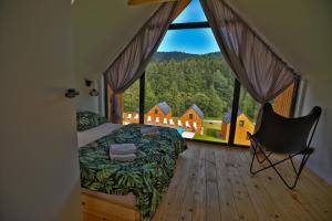 sypialnia z łóżkiem i dużym oknem w obiekcie Gwiazda Mogielicy basen & balia, sauna w mieście Słopnice