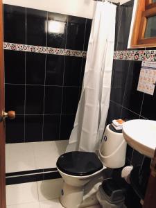 a black and white bathroom with a toilet and a sink at HOTEL RUTA 40 VILLA DE LEYVA in Villa de Leyva