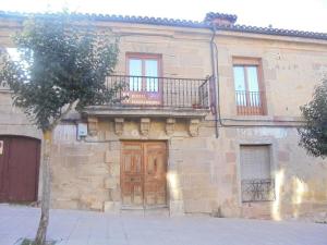 a stone building with a wooden door and a balcony at VUT Casa de la Catedral Baja in Sigüenza