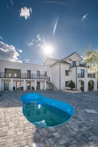 ein großes Haus mit einem blauen Pool davor in der Unterkunft Hotel Kralj in Kraljevo