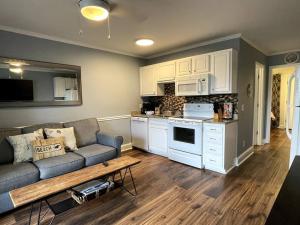 a living room with a couch and a kitchen at Crashin' Waves-Oceanview Bikes and King Bed in Hilton Head Island