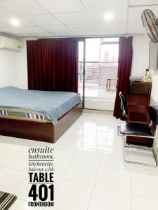 - une chambre avec un lit, une table et une chaise dans l'établissement Riverhome Saigon Apartments, à Hô-Chi-Minh-Ville