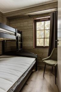 1 dormitorio con 1 cama, 1 silla y 1 ventana en Parkstigens Fjällby - Kåvan, en Funäsdalen