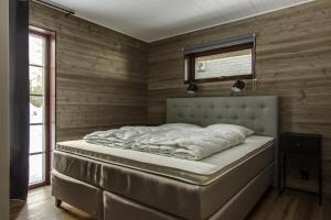 - un grand lit dans une chambre dotée de murs en bois dans l'établissement Parkstigens Fjällby - Kåvan, à Funäsdalen