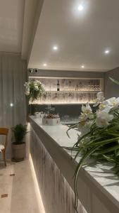 - une cuisine avec un comptoir fleuri dans l'établissement Hotel Dorè, à Castelnuovo del Garda