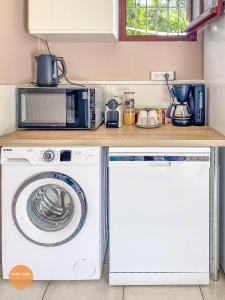 une cuisine avec un lave-linge et un micro-ondes dans l'établissement Villa Doucè Soley, à Rivière-Pilote