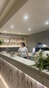 une femme debout derrière un comptoir dans une cuisine dans l'établissement Hotel Dorè, à Castelnuovo del Garda