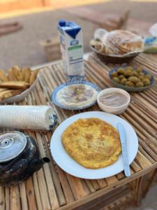 a table with a plate of food on a table at Red Twilight Camp in Disah