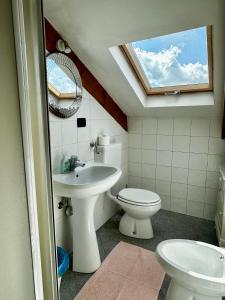 uma casa de banho com um WC e um lavatório com uma clarabóia em Il viandante em Turim