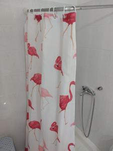 a shower curtain with a red flamingos on it at Marilena Rooms Plataria in Plataria