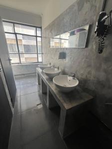 a bathroom with three sinks and a row of windows at Urban Rooms in Athens