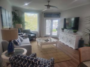 a living room with a couch and a tv at The Moorings Condo - Wild Dunes Resort - Isle of Palms Marina in Isle of Palms