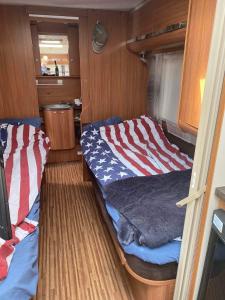 a room with a bed with an american flag blanket at Ramsbytorp in Kågeröd