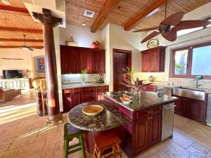uma cozinha com uma mesa e uma ventoinha de tecto em Villa Durazno em Guanacaste