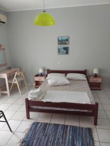 a bedroom with a bed and two tables and a green light at Marilena Rooms Plataria in Plataria