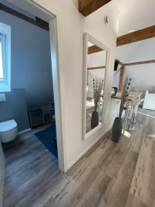 a bathroom with a mirror and a toilet and a table at FeWo Loft in Balingen
