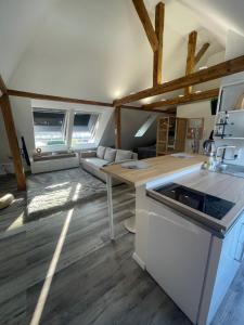 una cucina e un soggiorno con pavimenti e travi in legno. di FeWo Loft a Balingen