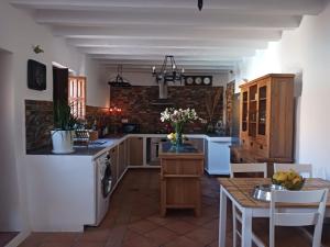 una cucina con elettrodomestici bianchi e tavolo con sedie di Casa rural los Cerezos a Albox