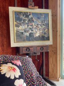 a painting hanging on a wall next to a bed at Exceptional house on the waterfront in Reeuwijk