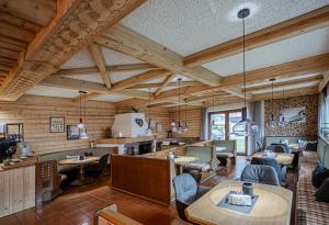 a restaurant with wooden ceilings and tables and chairs at Pension Eschenhof in Kaprun