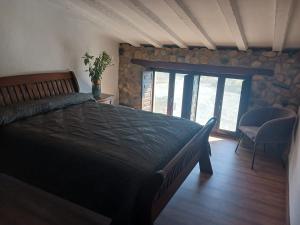 una camera con un grande letto e un muro di pietra di Casa rural los Cerezos a Albox
