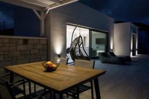 a dining room table with a bowl of fruit on it at Anthelia Luxury Villas in Karpathos Town