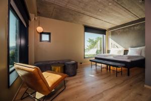 a bedroom with a bed and a couch and a chair at Comfort Hotel Porsgrunn in Porsgrunn