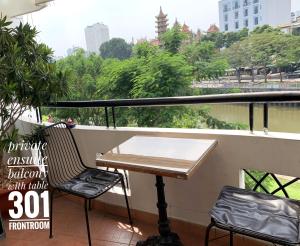 d'une table et de deux chaises sur un balcon avec vue. dans l'établissement Riverhome Saigon Apartments, à Hô-Chi-Minh-Ville