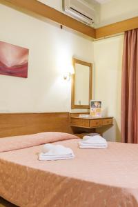 um quarto de hotel com uma cama e um espelho em CiTYZen Hotel em Loutraki