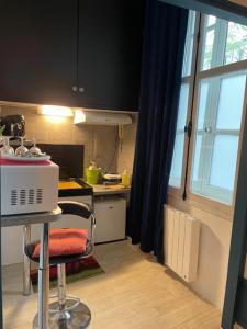 cocina con encimera y silla en una habitación en L’insolite en Saintes