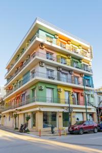 a tall building with colorful balconies on a street at CiTYZen Hotel in Loutraki