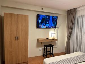 1 dormitorio con escritorio y TV en la pared en Resort-inspired Condo with Queen-size bed & 50-inch Smart TV, en Cebú